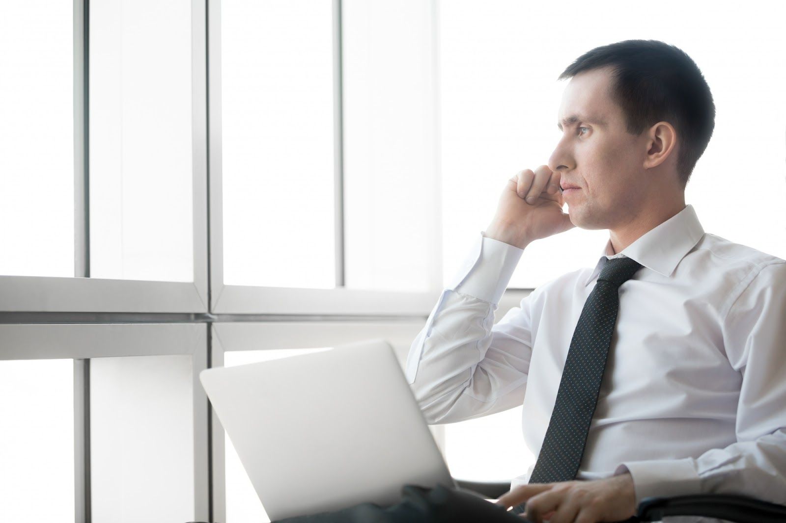 A person in a tie and tie holding a computerAI-generated content may be incorrect.
