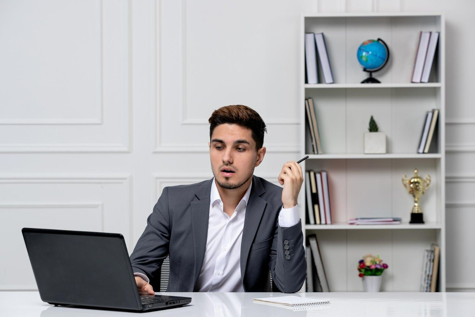 A person sitting at a desk with a computer and a penAI-generated content may be incorrect.
